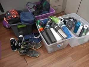 water bottles and lunchboxes in lost and found bin